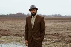 Donny is wearing an 80's brown suit with a pale green button down shirt and vintage grey fedora and vintage loafers.