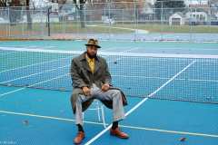 Donny is wearing a vintage double-breasted trench, 80's mustard shirt with silver buttons, a 50's olive green vintage fedora and leather loafers.