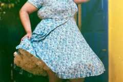 Hailey, wearing a floral blue dress with crinoline, vintage head-piece and metallic pumps.