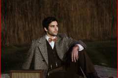 Myles, wearing brown wool pants, wool vest, white button down shirt 50's tweed coat and rose bowtie.