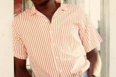 Franklin, wearing powder blue dress pants,50's red and white stripe button up shirt, paired with matching brown leather, blue and white stripe belt.